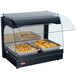 A Hatco countertop hot food display warmer with food in a glass-covered buffet.