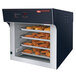 A Hatco Flav-R-Savor pass-through heated air curtain above trays of food in a commercial oven.
