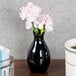 An American Metalcraft black ceramic jug vase with pink flowers.