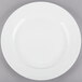 A Tuxton AlumaTux pearl white china plate with a white rim on a gray surface.