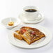 A Tuxton Modena AlumaTux Pearl White china saucer with a plate of french toast and a cup of coffee.