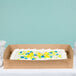 A Baker's Mark Kraft full sheet cake box with a cake decorated with frosting flowers.