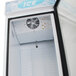 A white Turbo Air ice merchandiser with a glass door open and a vent.