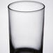A close up of a clear Libbey juice glass with a small black rim.