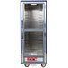 A blue Metro C5 heated holding cabinet with clear dutch doors and shelves.