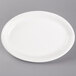 A Tuxton white oval china coupe platter on a gray surface.