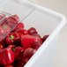 A Cambro 32 gallon vegetable crisper container full of red peppers.