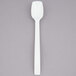 A white polycarbonate salad bar spoon with a black handle.