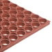 A close up of a red Notrax rubber floor mat with holes.