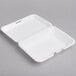 A white foam rectangular takeout container with a perforated hinged lid.