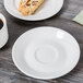 A Tuxton San Marino saucer with a pastry on a table.