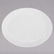 A Tuxton San Marino AlumaTux Pearl White oval china platter on a gray surface.