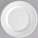 A close-up of a Tuxton AlumaTux Pearl White China plate with a curved edge and wavy design.