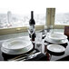 A table set with Tuxton AlumaTux china plates and wine glasses.