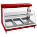 A red Hatco countertop display case with glass doors and clear shelves holding three trays.