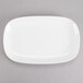 A white rectangular Tuxton china platter with a white rim on a gray background.