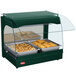 A Hatco Green Glo-Ray curved countertop food warmer with food in metal pans.