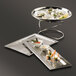 An American Metalcraft hammered stainless steel tray with a variety of food on small silver plates.