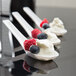 Three WNA Comet white Asian soup spoons with yogurt and berries on them.