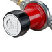 A close-up of a red and black Backyard Pro gas regulator with a red hose.