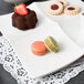 A white porcelain tapas tray with three different desserts on it.