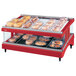 A Hatco red slanted heated glass display case with food on trays.