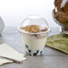 A Squat Parfait Cup with Fabri-Kal insert and dome lid filled with yogurt, granola, and blueberries.