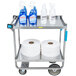 A Lakeside stainless steel utility cart with rolls of toilet paper and bottles of cleaning supplies on it.