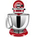 A red KitchenAid Artisan stand mixer with a silver band on the head.