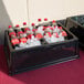 A black Geneva beverage bin filled with ice and soda bottles.