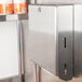 A stainless steel Bobrick surface-mounted paper towel dispenser filled with C-fold or multifold paper towels.