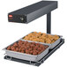 A Hatco portable heated food warmer with two trays of meatballs and chicken on a counter.