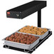 A Hatco heated food warmer holding trays of meatballs and chicken on a counter.
