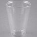 A Solo Ultra Clear PET plastic cup filled with a drink on a grey surface.
