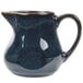 A Tuxton Artisan Night Sky China creamer in blue with a handle.