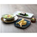 A Tuxton TuxTrendz Artisan Night Sky square china plate with sushi, salad, and rice on a table.