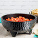 A black GET Viva Mexico melamine molcajete bowl filled with salsa and chips.