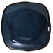 A blue square Tuxton Artisan china plate with a black rim on a white background.
