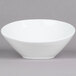 A Tuxton porcelain white bowl with a small rim on a gray background.