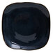 A dark blue square Tuxton Artisan china plate with a black rim.