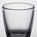 A clear glass Arcoroc shot glass with a rim.