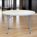 A gray NPS round folding table with metal legs.