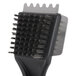 A close-up of a black Waring grill brush with a metal handle.