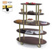 A Geneva oval serving cart with wooden shelves holding cakes.