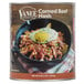 A Vanee #10 can of corned beef hash on a white background with a bowl of food and a fried egg on top.