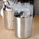 An American Metalcraft stainless steel French fry cup filled with silverware.