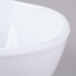 A close up of a Thunder Group Classic White Melamine Round Bowl with a curved edge.