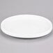 An American Metalcraft Prestige white porcelain plate with a circular rim on a gray surface.