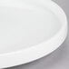 A close-up of a white American Metalcraft Prestige porcelain serving plate with a circular rim.