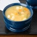 A close up of a blue Cambro Shoreline Collection bowl filled with soup.